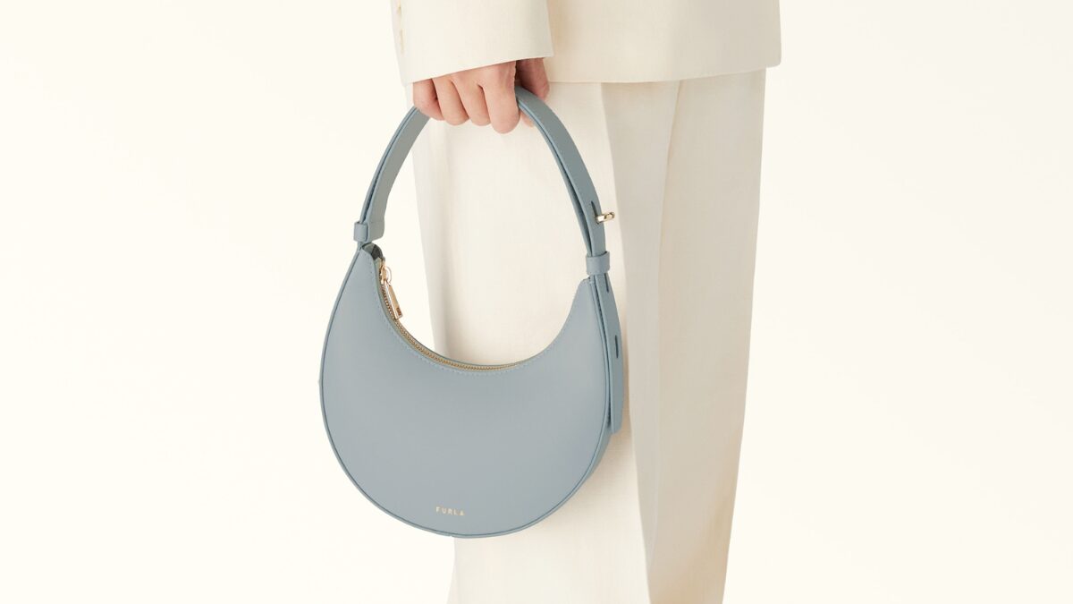 フルラのバッグを持っている女性。ライトブルーの半月型のデザインバッグ